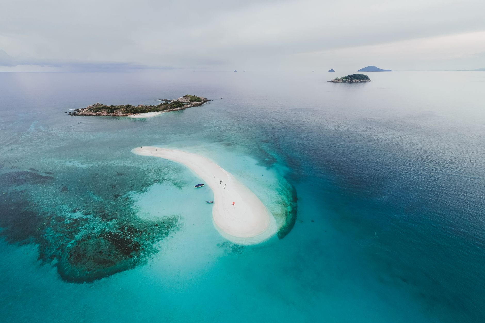 An aerial view of a tropical island and turquoise water