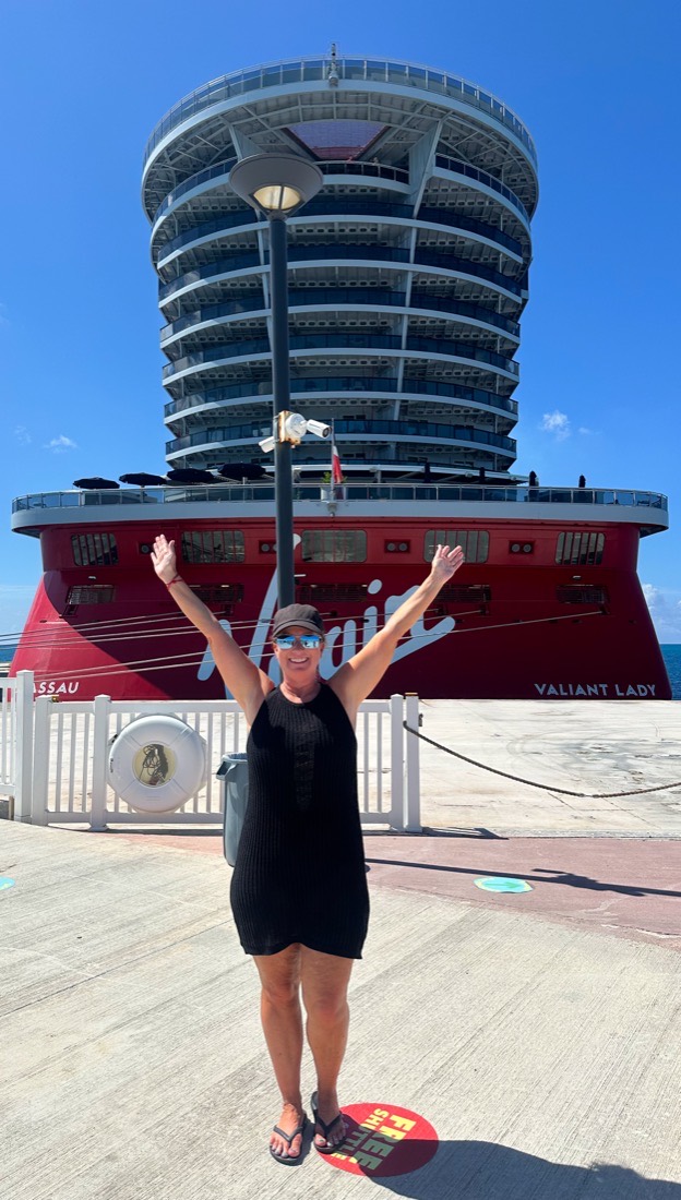 Liz in front of Virgin Voyages' Valiant Lady on the dock